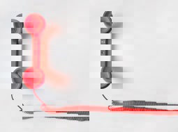 red corded telephone on a pale background