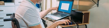 man using a wheelchair working at computer