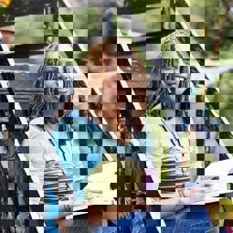 Carer Jaycee sitting on steps with notebook