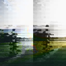 woman pushing person in wheelchair across a field