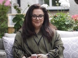 Carer Niki sitting on her sofa