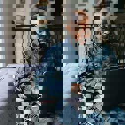 man in bedroom using a laptop