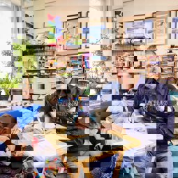 Carer at home, sitting at table with form, smiling